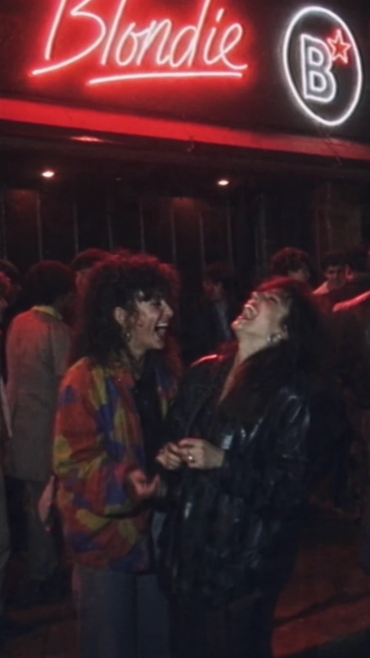 Blondie Club × 80s Party — partygoers beneath the neon club sign, still from the final video