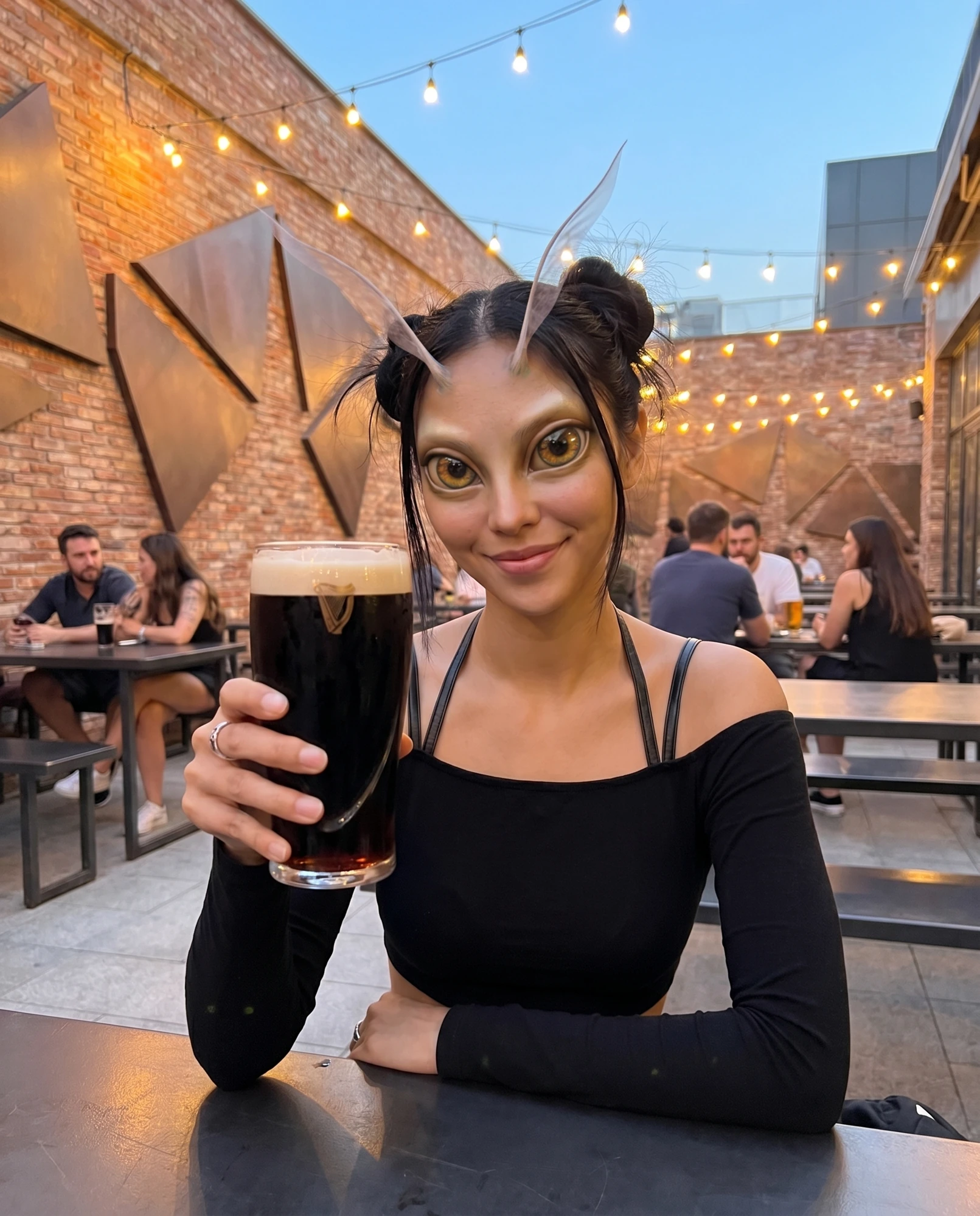 An antennaed character raises a dark beer in a courtyard.
